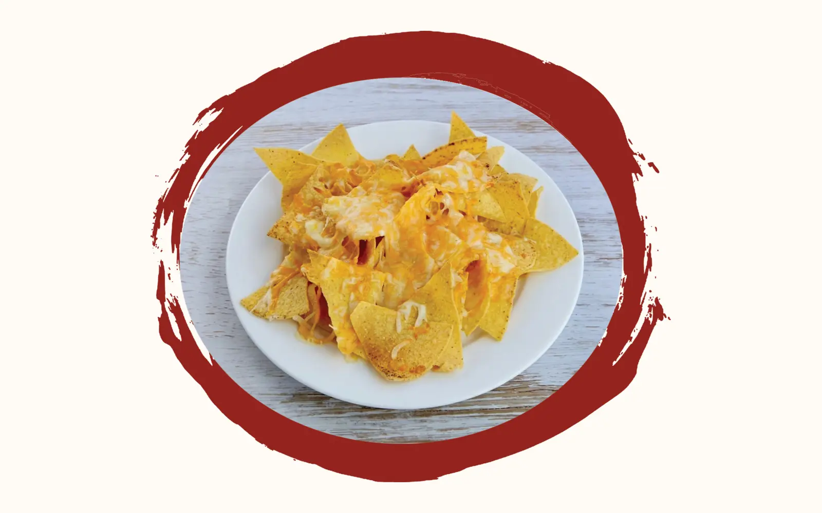 Weisser Teller mit überbackenen Maistortilla-Chips, geschmolzener Cheddar und Mozzarella darüber, auf hellem Holztisch
