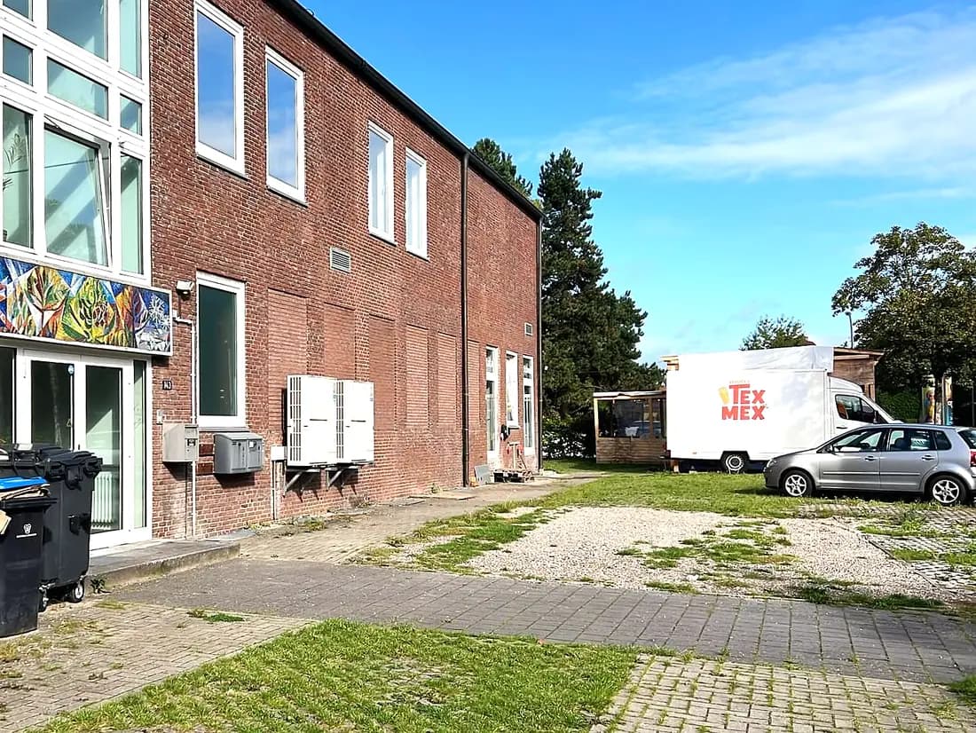 Das Backsteingebäude Tangstedter Landstraße 143 mit sichtbarer Hausnummer, rechts der weisse Wagen